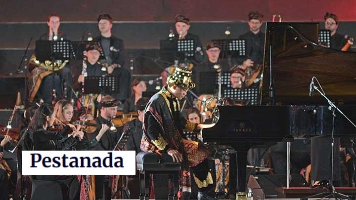 A pianist in ornate attire performs on stage accompanied by an orchestra, creating a vibrant musical experience.
