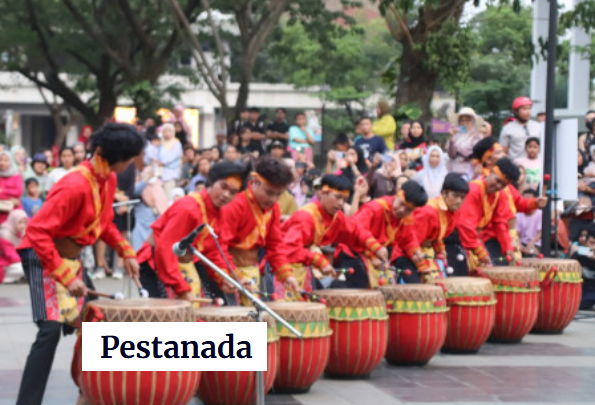 A vibrant group of drummers wearing red outfits performing in a lively outdoor setting, surrounded by an engaged audience.
