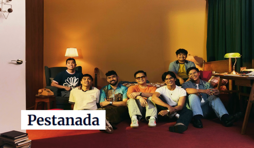 A group of young individuals sitting on a red carpet in a warmly lit room, showcasing friendship and comfort.